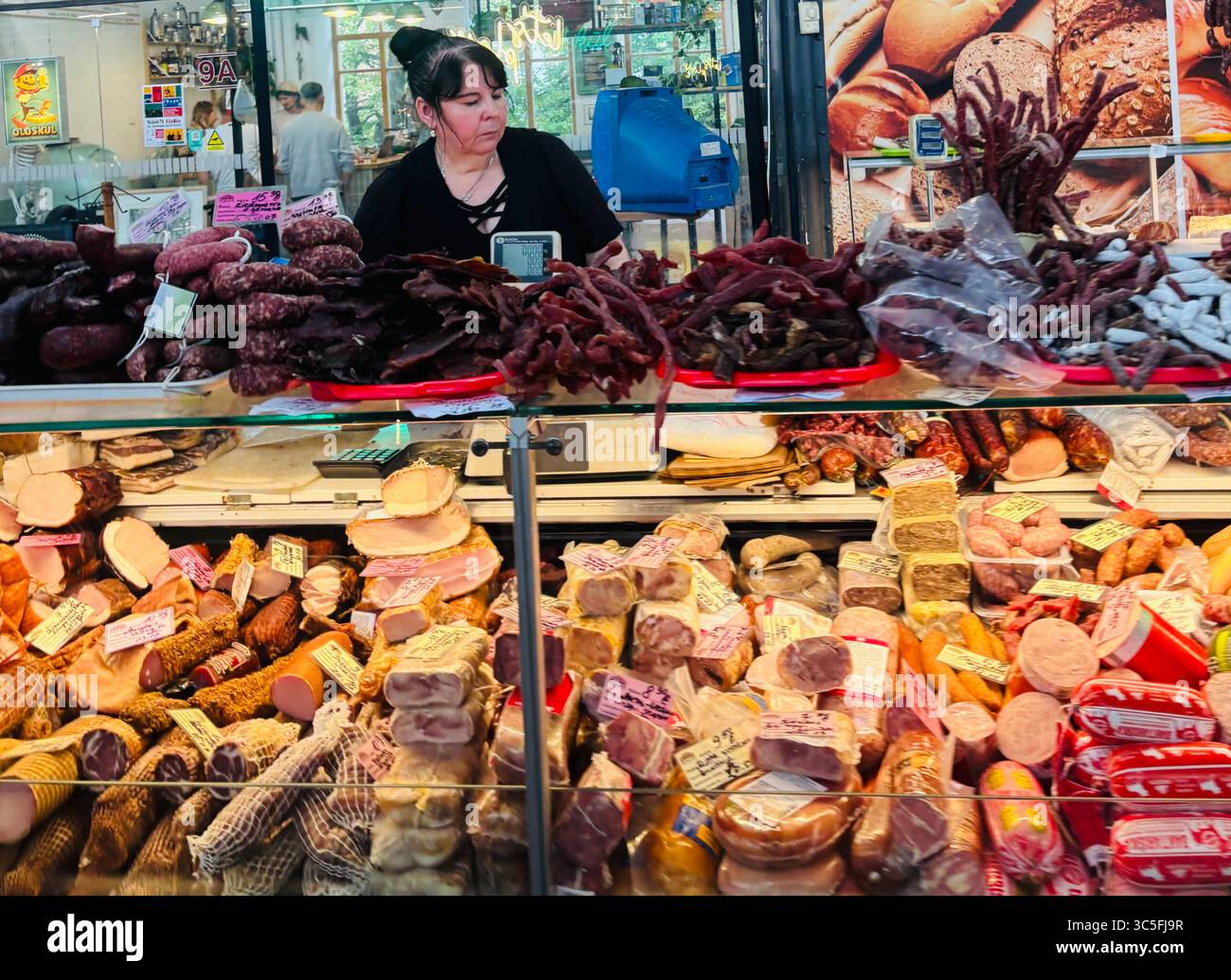 A cured meat vendor at the Halės Turgus market in Vilnius, Lithuania. - Smartphone Captured Stock Image