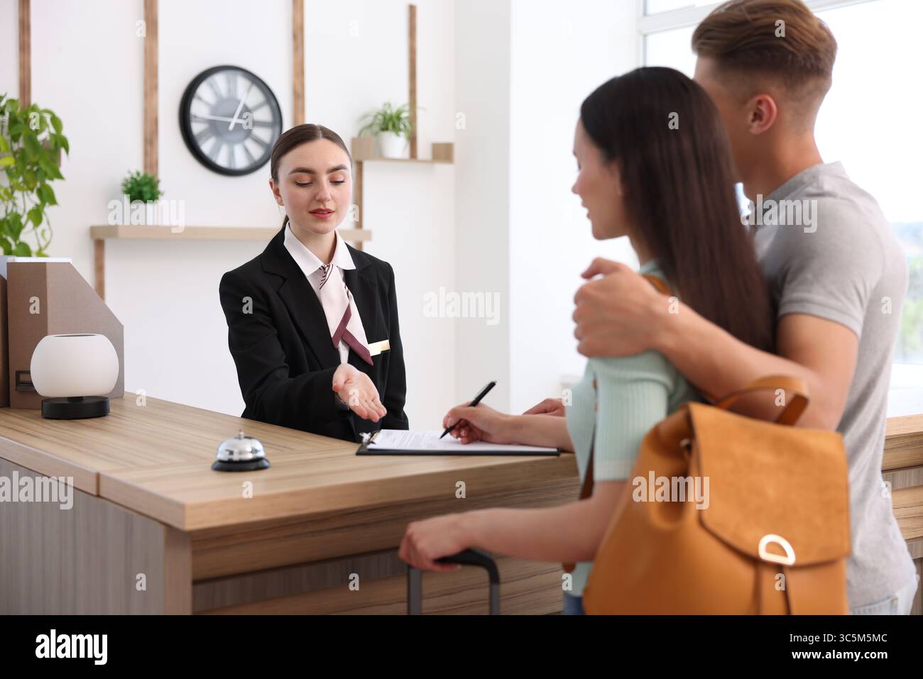 Receptionist working with clients at reception desk in hotel Stock ...