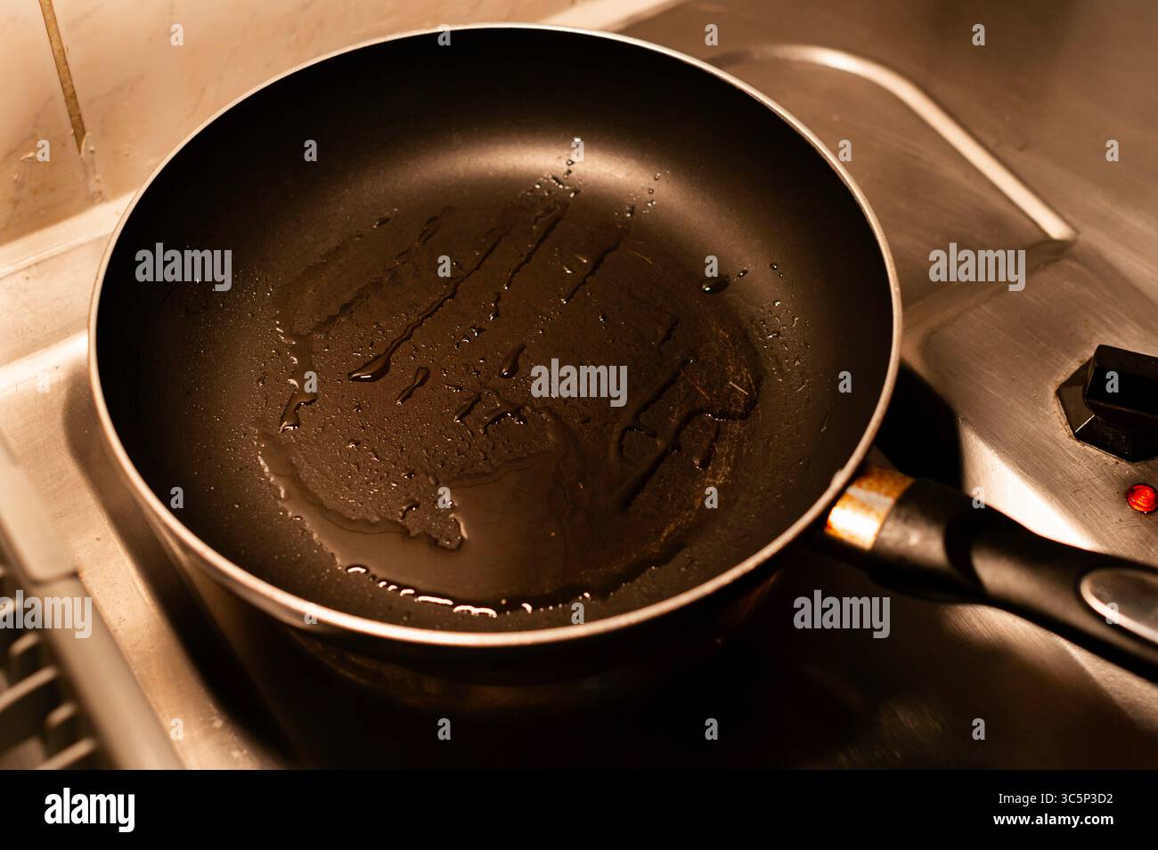 Cooking oil heating in a non-stick frying pan Stock Photo