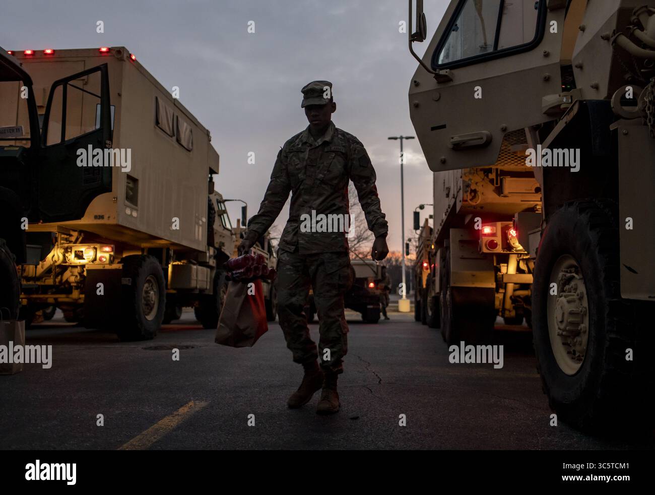 March 26, 2020, IL, USA: Members of the Illinois National Guard assemble at their convoy before sunrise Thursday, March 26, 2020 in the parking lot of Rivers Casino to begin the day's work. The Guard is running a coronavirus testing facility open to first responders on the Northwest Side. (Credit Image: © TNS via ZUMA Wire) Stock Photo