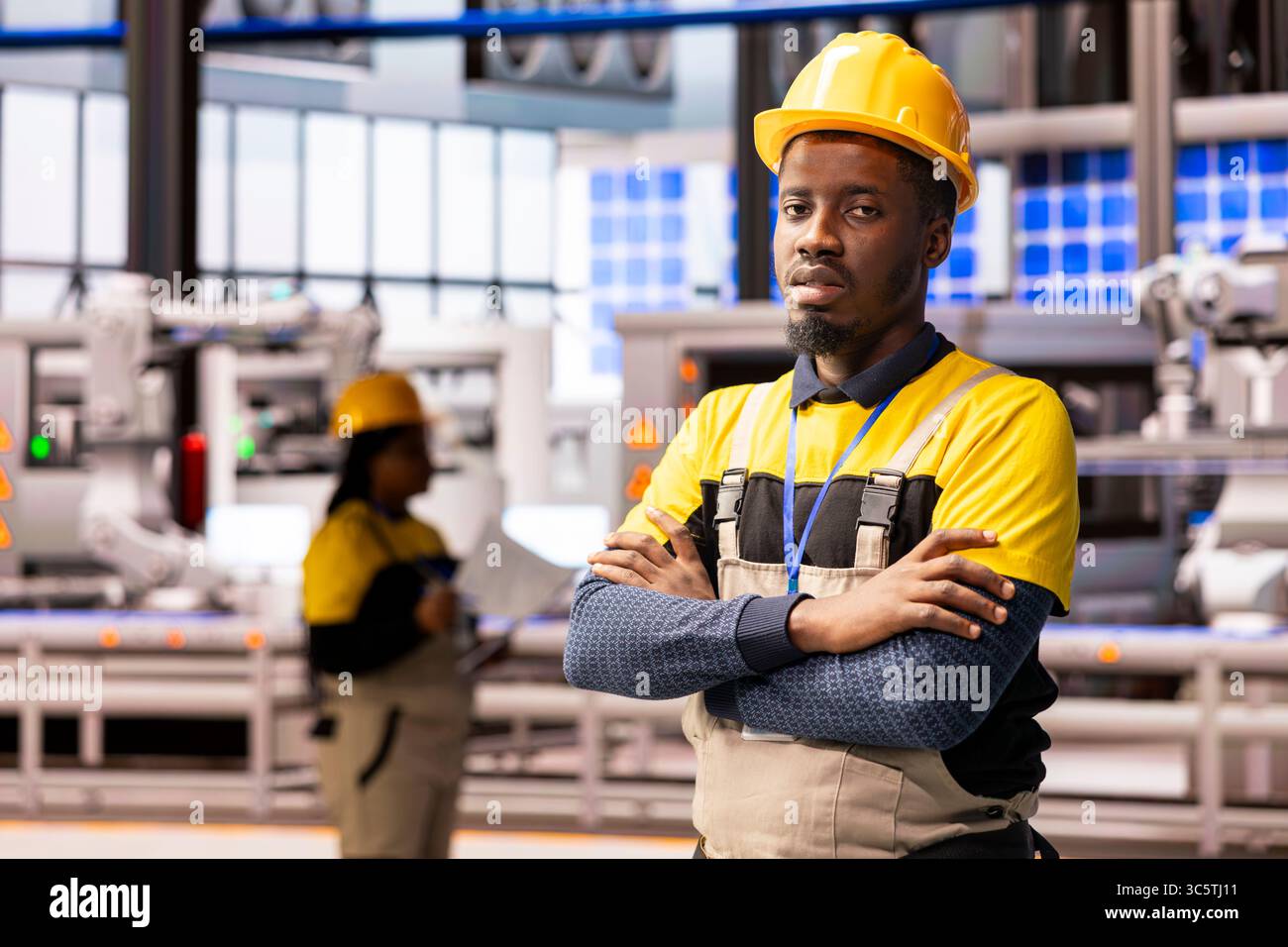 Male technician in automated manufacturing plant stands in front of