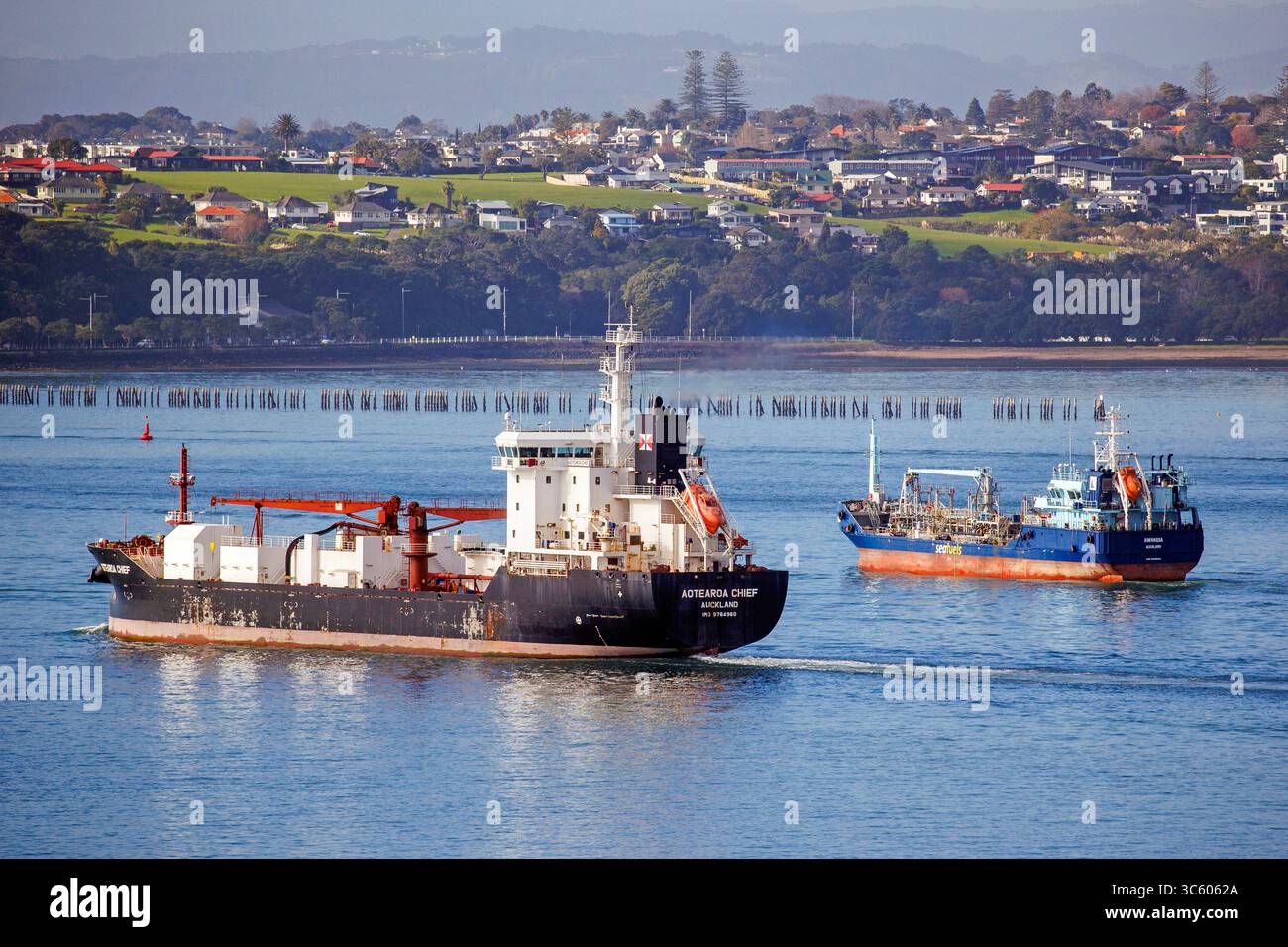 Golden Bay Cement’s bulk cement carrier,  the MV Aotearoa Chief departs from the Ports of Auckland followed by the bunker barge Awanuia Stock Photo