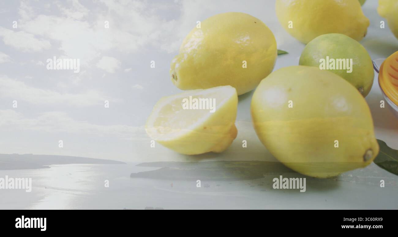 Displaying close-up lemons and lime on studio tabletop, with green citrus leaves, copy space Stock Photo