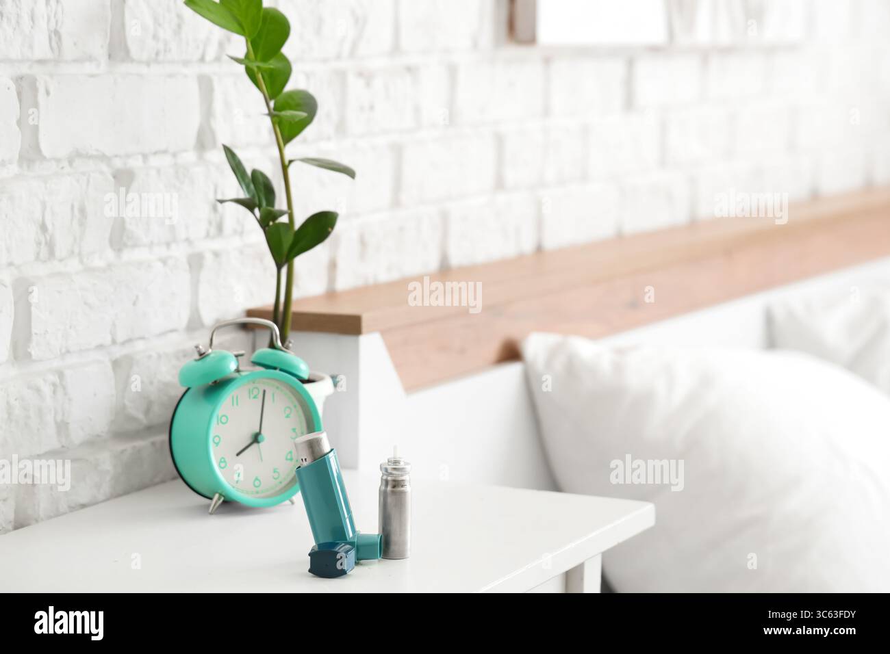 Modern inhaler and asthma aerosol canister on bedside table, closeup ...