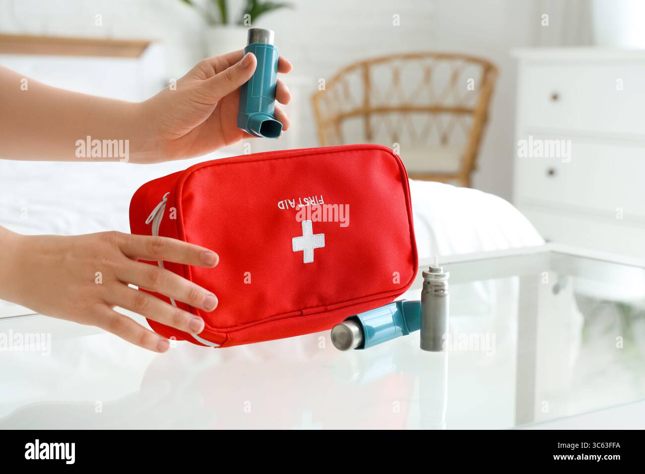 Woman taking modern inhaler and first aid kit from table in bedroom ...