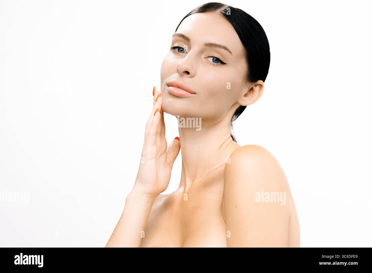 Female model with flawless complexion is softly touching her face ...