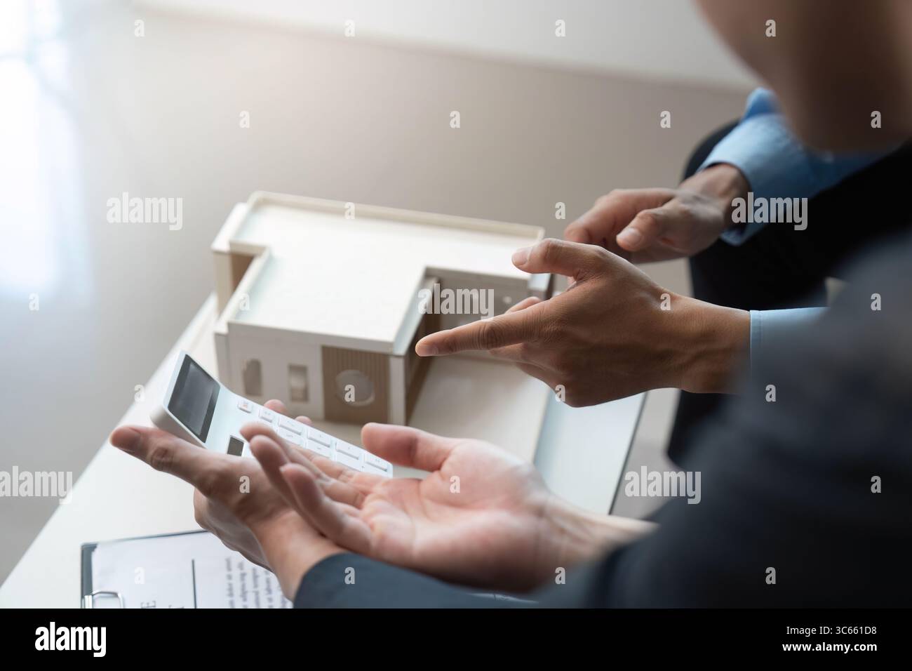 Design Presentation. Architects discussing building model and project specifications. Stock Photo