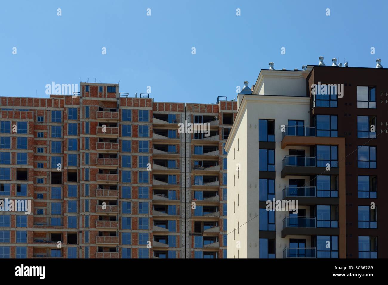 Side-by-side view of a modern finished apartment building and an ...