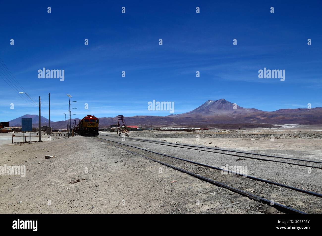 Volcanic Train GL26 C-2 diesel #2006 with freight train at Ollagüe, Aucanquilcha ...