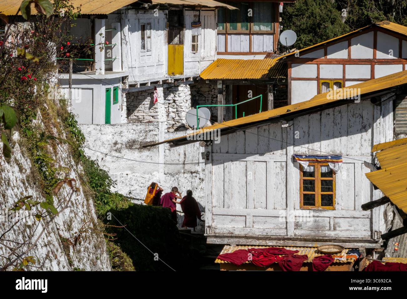 Monks walk amongst the buildings of Tawang Monastery, Tawang, Arunachal Pradesh, India Stock Photo