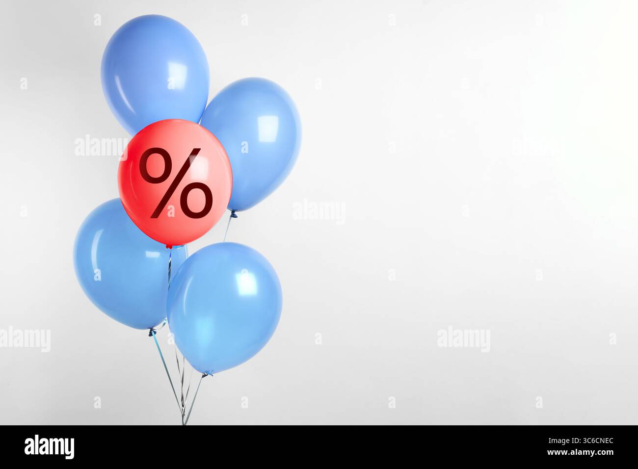 Red balloon with percent sign among light blue ones against light background. Hot sale, special offer Stock Photo