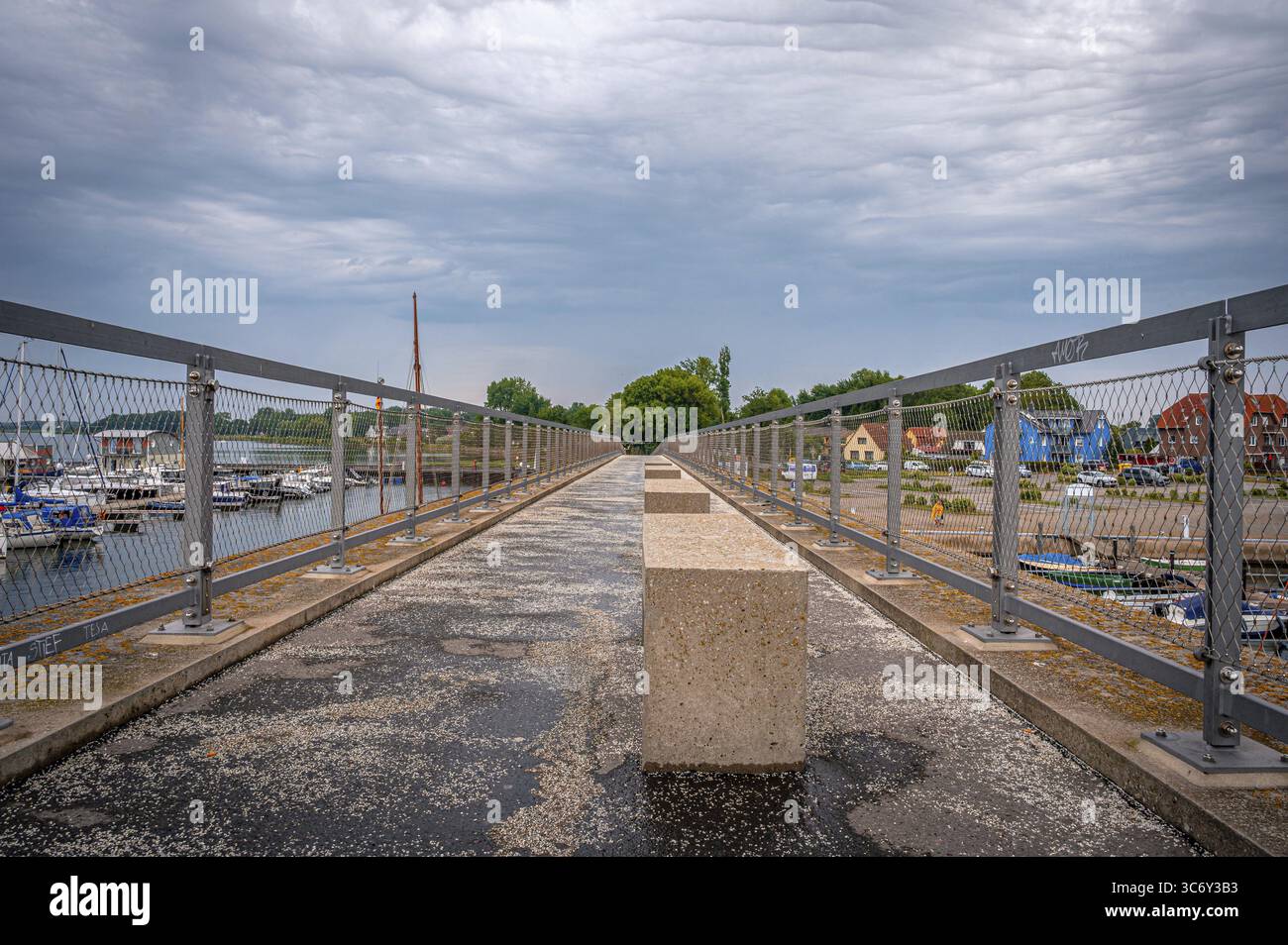 Long walkway on the historic chalk bridge with railings and cloudy view ...