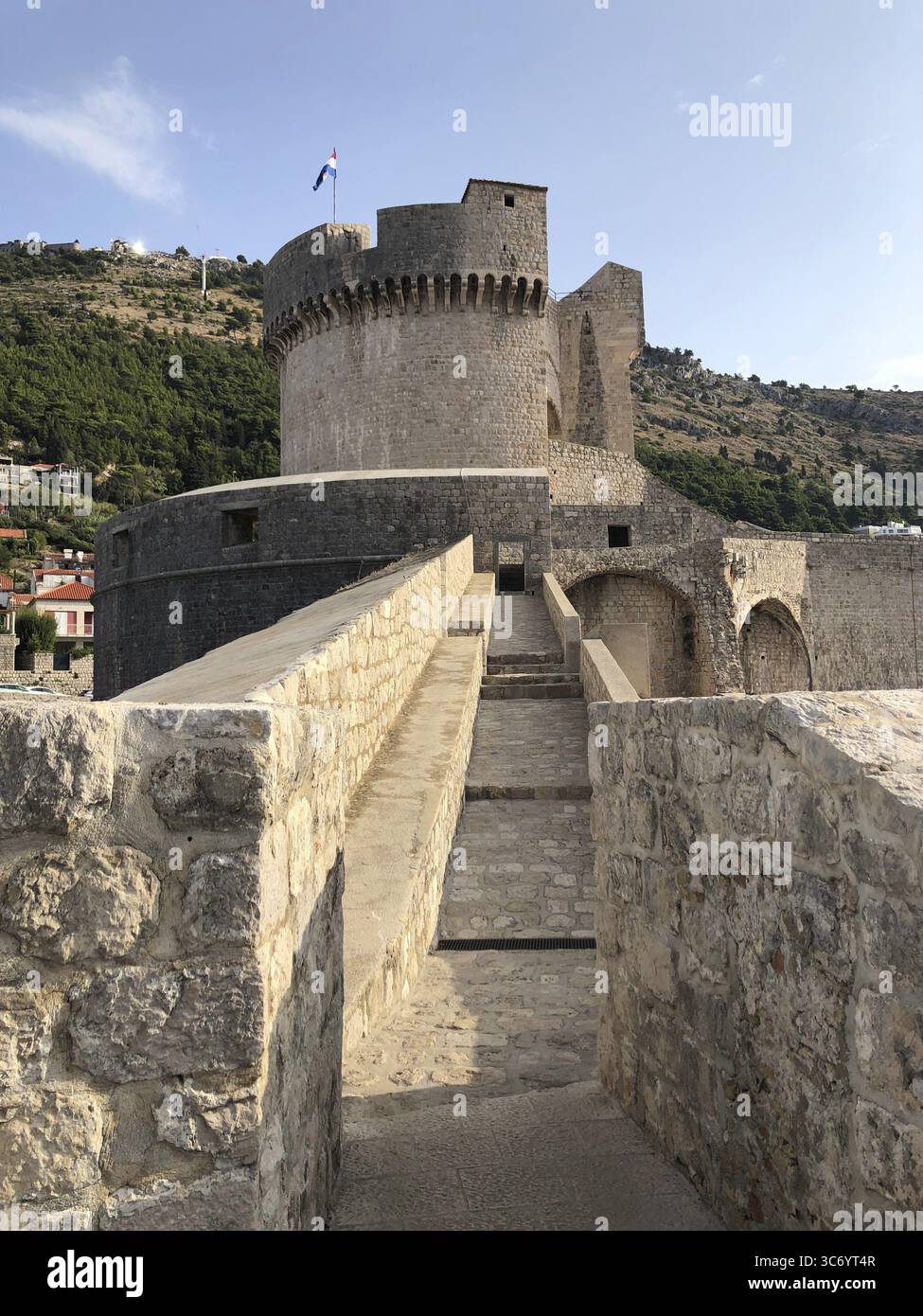 Massive historic stone structure with watchtower, adjacent to the coast, Dubrovnik, Croatia Stock Photo