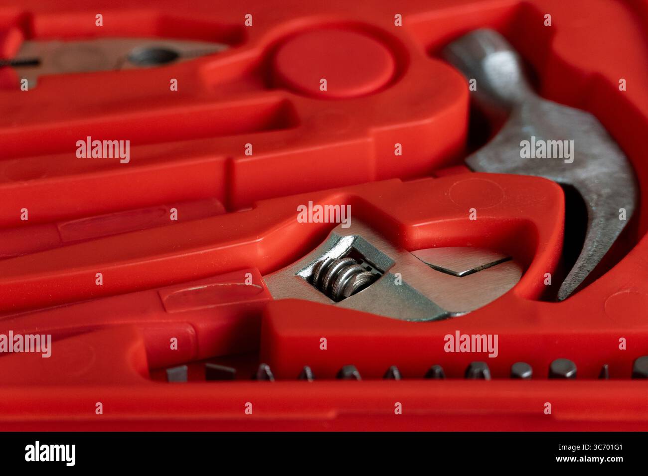 Detailed close-up image of various hand tools neatly arranged in a bright red plastic case, highlighting metallic textures and organized compartments Stock Photo
