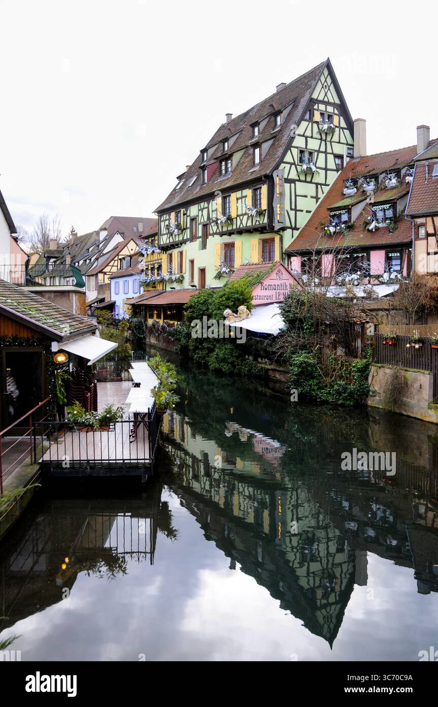 Traditional Alsatian houses in Colmar reflect perfectly in the calm canal waters, creating a mirror-like image of colorful facades and wooden architec Stock Photo