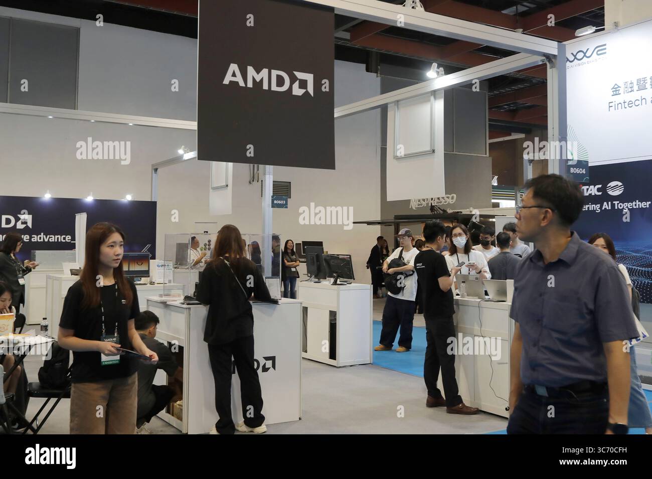 Visitors walk by AMD booth at the AI Wave Show exhibition in Taipei ...