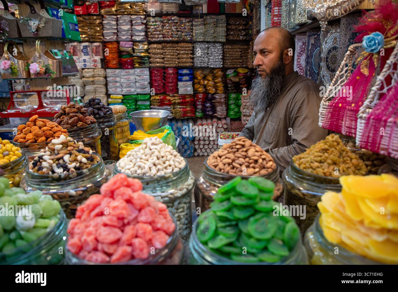 Srinagar, India. 01st Aug, 2025. A Kashmiri shopkeeper sells dry fruits as  he waits for customers