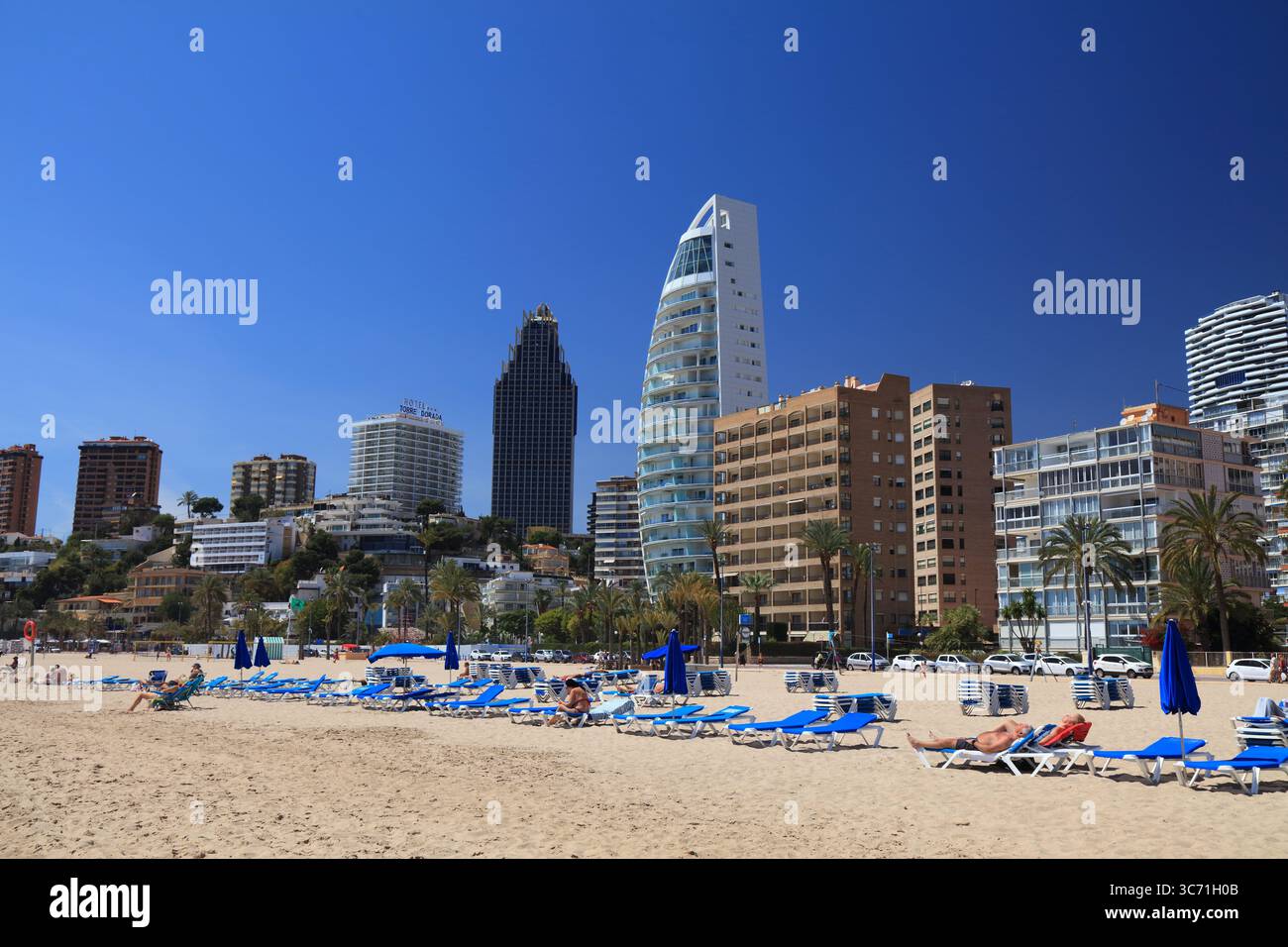 BENIDORM, SPAIN - APRIL 9, 2025: People spend the time on Poniente beach in Benidorm, Spain on a sunny weather day. Stock Photo