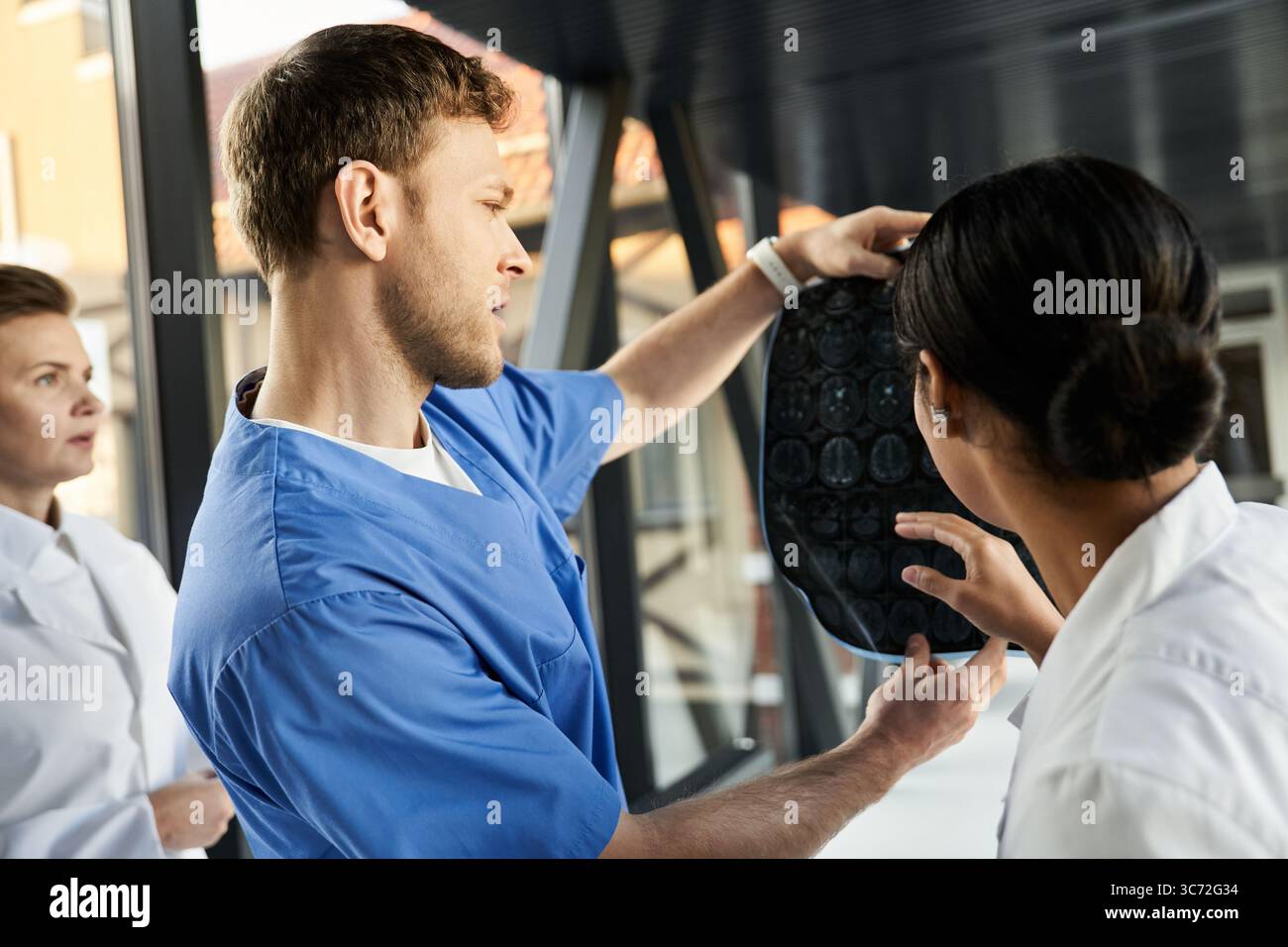 Three multicultural doctors discuss a patients scan in a bright ...