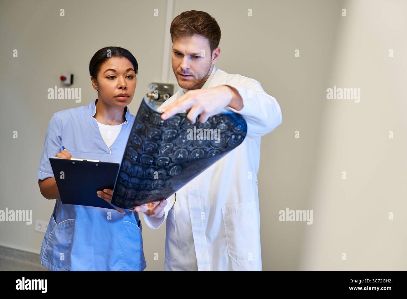 Two doctors review MRI scans as they work together in a state-of-the ...