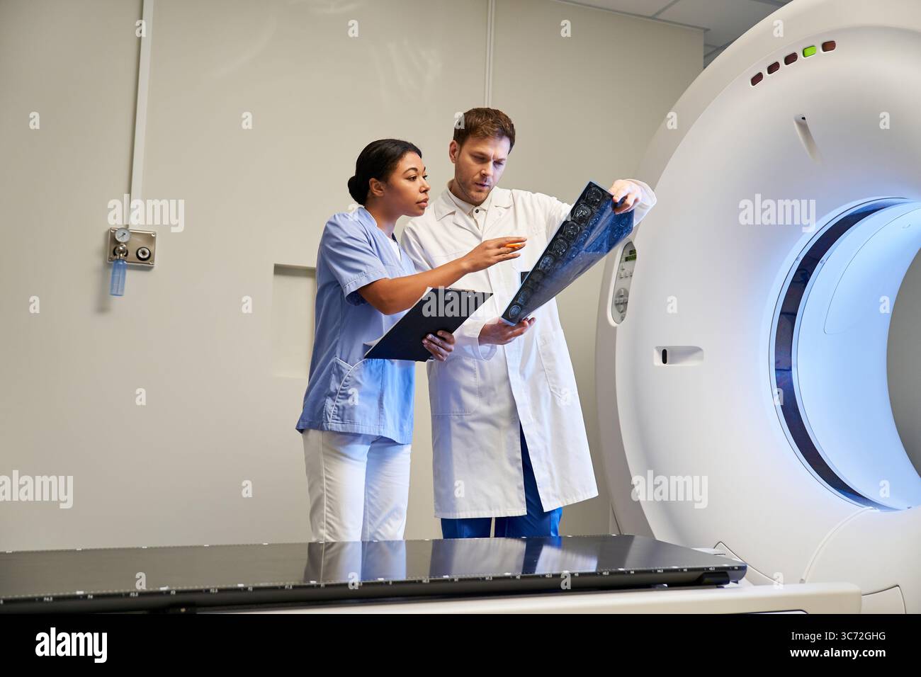 Doctor Using Mri Two doctors collaborate on an MRI scan in a state-of-the-art hospital ...