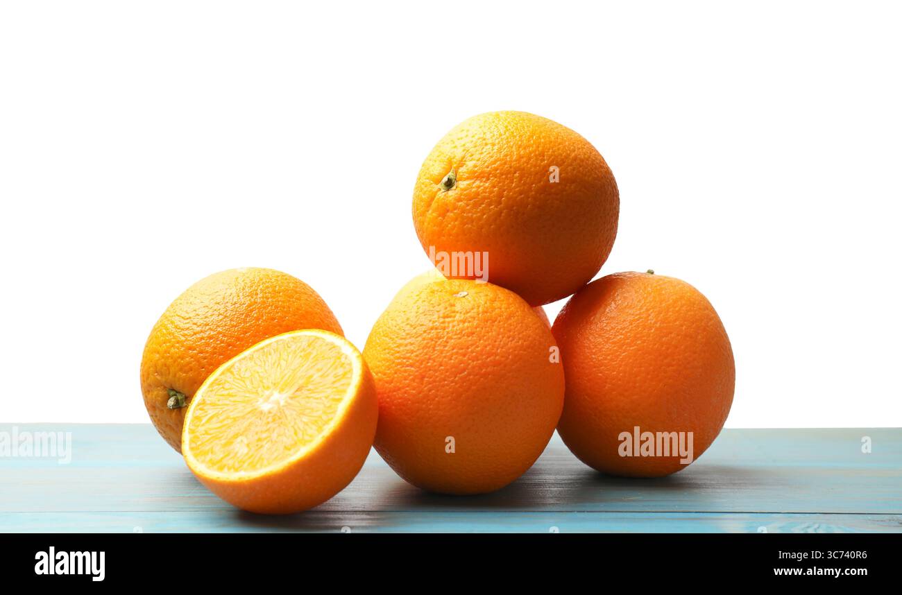 Pile of juicy oranges on light blue wooden table against white ...