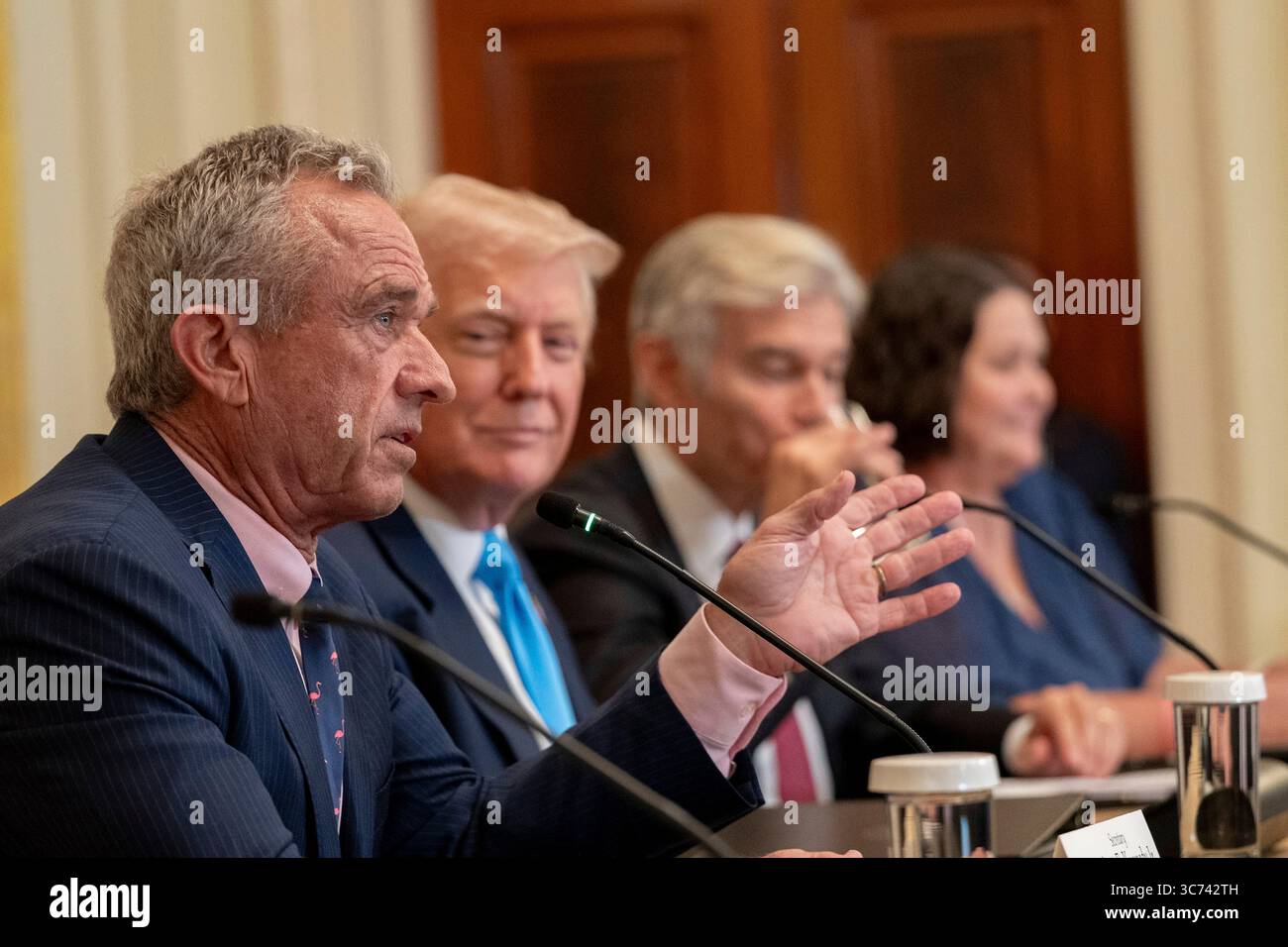 Washington, United States. 30 July, 2025. Health and Human Services Secretary Robert Kennedy Jr., left, delivers remarks as U.S President Donald Trump, 2nd left, looks on during a “Making Health Technology Great Again” event at the East Room of the White House, July 30, 2025, in Washington, D.C.  Credit: Joyce Boghosian/White House Photo/Alamy Live News Stock Photo