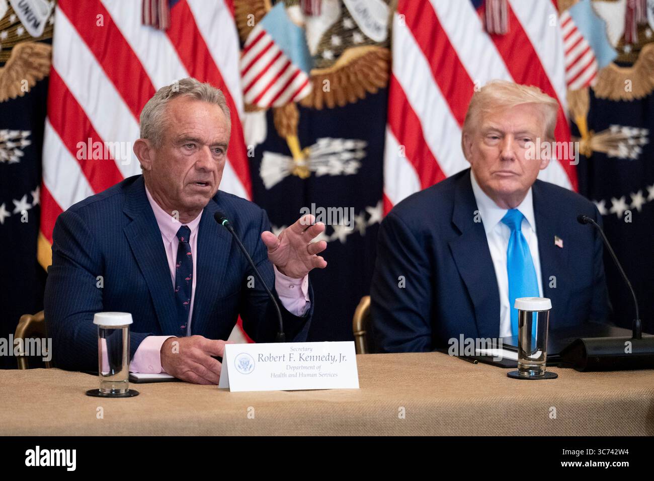 Washington, United States. 30 July, 2025. Health and Human Services Secretary Robert Kennedy Jr., left, delivers remarks as U.S President Donald Trump, right, looks on during a “Making Health Technology Great Again” event at the East Room of the White House, July 30, 2025, in Washington, D.C.  Credit: Jack Power/White House Photo/Alamy Live News Stock Photo