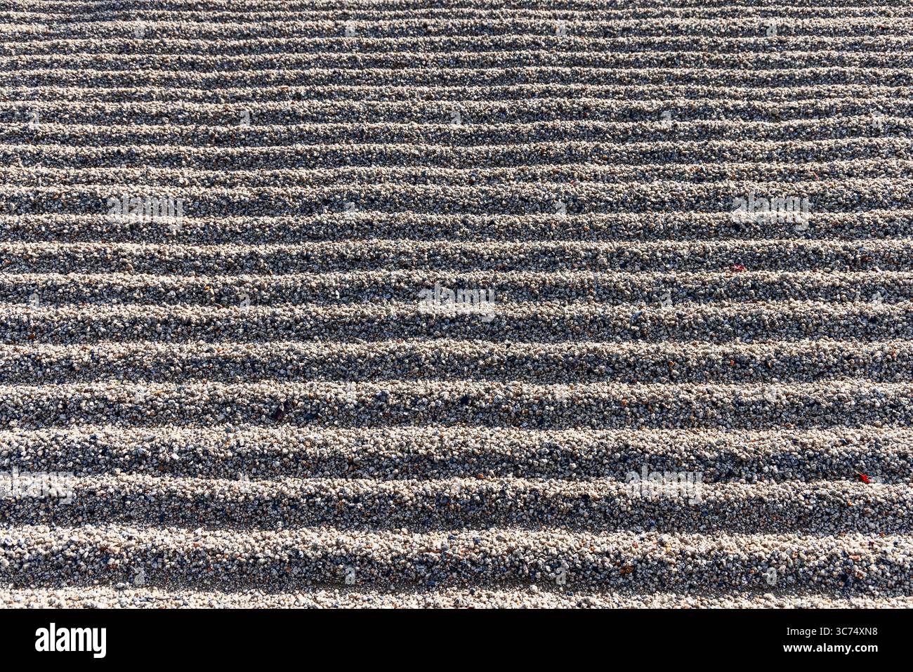 Textured gravel surface with evenly spaced horizontal lines formed by ...