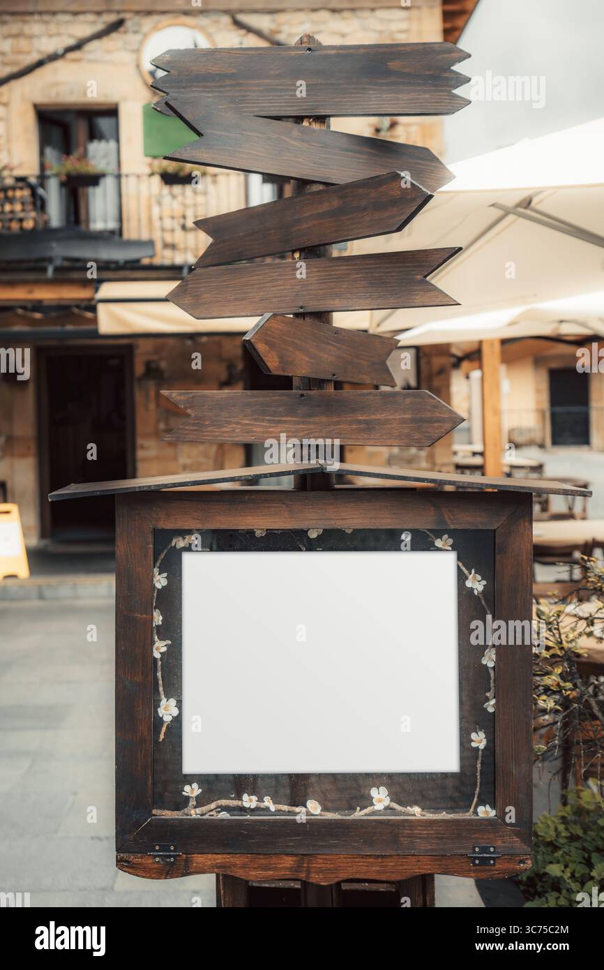 Rustic wooden signpost with multiple blank directional arrows pointing ...