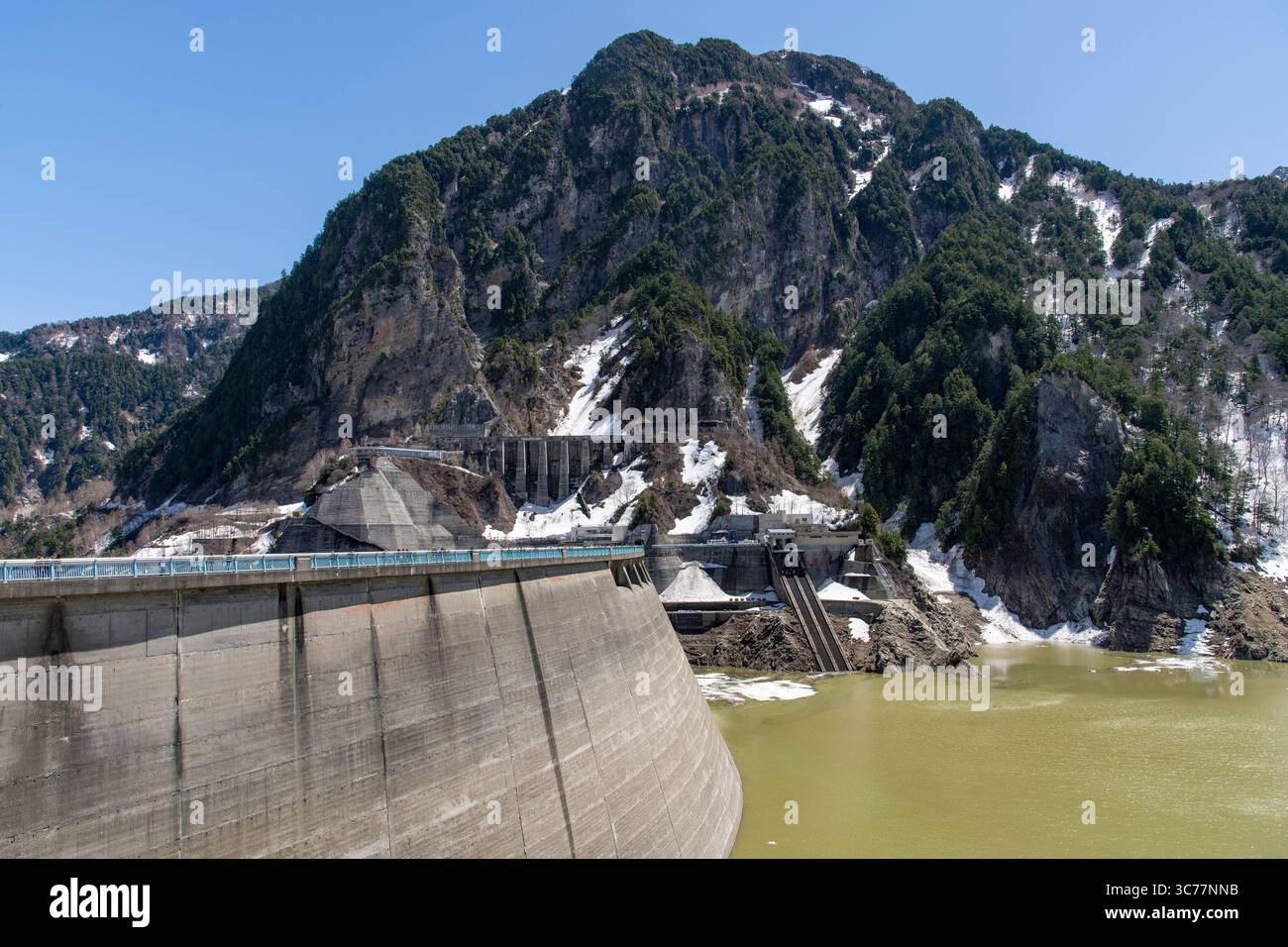 Tateyama, Japan - April 24, 2025: The Kurobe Dam on the snow-covered Tateyama Kurobe Alpine Route in the Tateyama Mountain Range Northern Japan Alps, Stock Photo