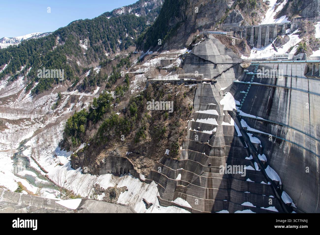 Tateyama, Japan - April 24, 2025: The Kurobe Dam on the snow-covered Tateyama Kurobe Alpine Route in the Tateyama Mountain Range Northern Japan Alps, Stock Photo