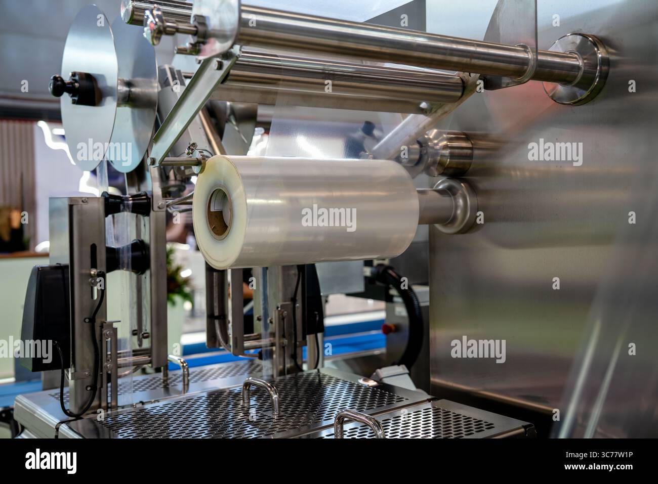 Packaging film roll on automated sealing equipment in food industry ...