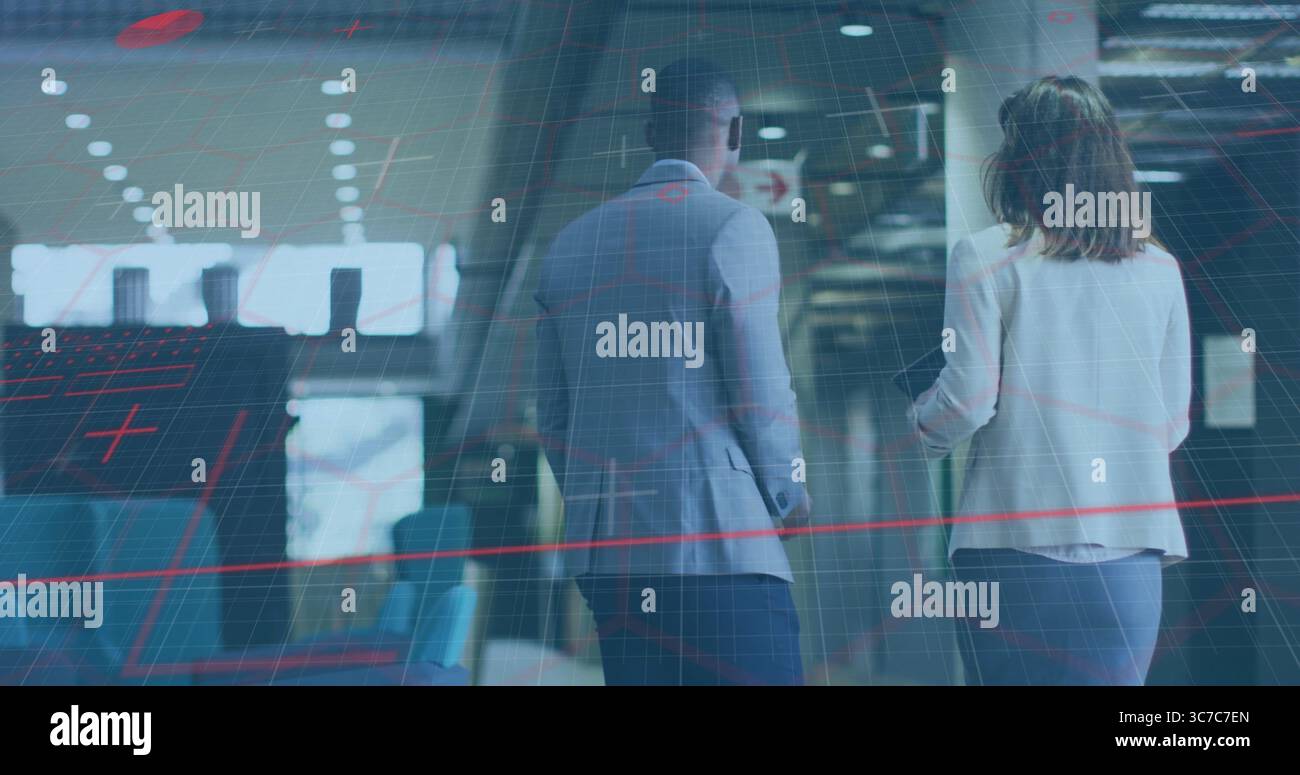 Business colleagues walking in terminal, passing blue seats windows pillars lights and arrow sign Stock Photo