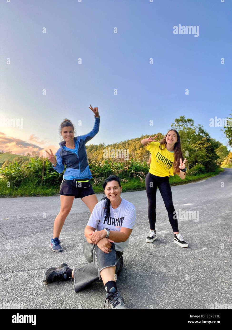 Participants running and hiking through lush forest trails and historic town streets during the Trail Real Priolo event in São Miguel Island, Azores, - Smartphone Captured Stock Image