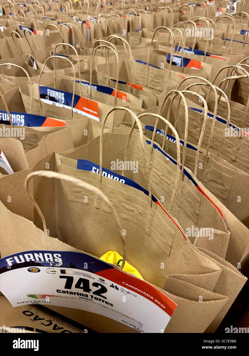Kit bags with participant bib numbers prepared for the Furnas Night Trail running event in the Azores islands, Portugal. - Smartphone Captured Stock Image