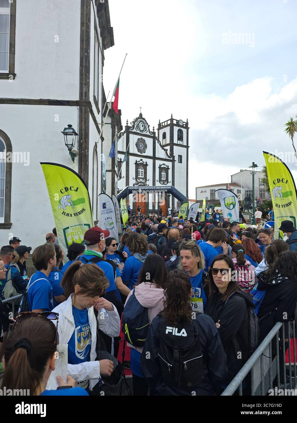 Participants running and hiking through lush forest trails and historic town streets during the Trail Real Priolo event in São Miguel Island, Azores, - Smartphone Captured Stock Image