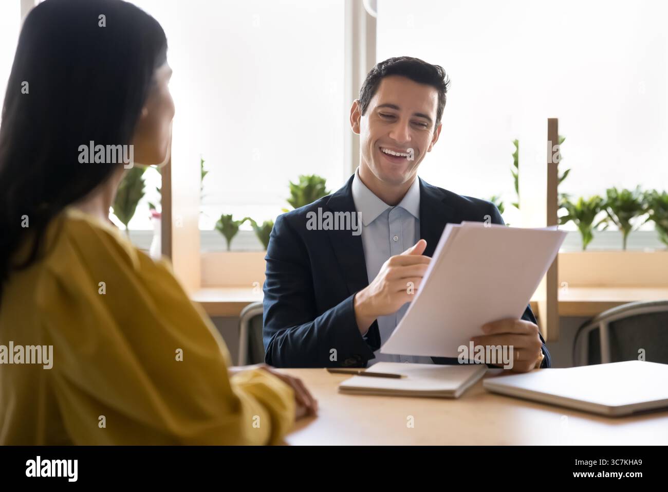 Businessman holds papers, conducting job interview or meeting in office Stock Photo