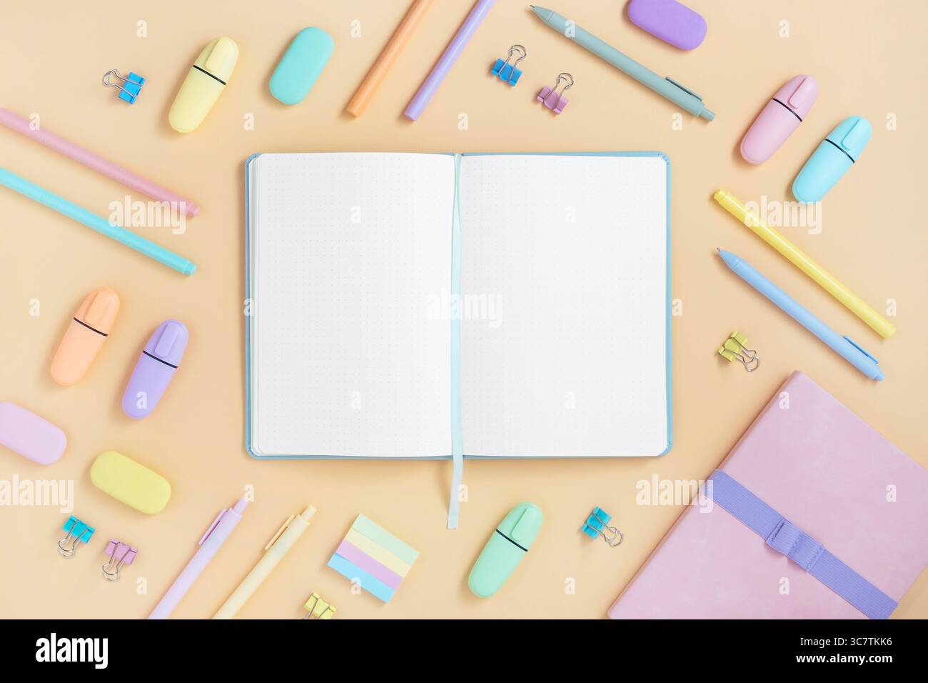 Open notebook with space for your text with pastel color school and office stationery on yellow background. Flatly. Stock Photo