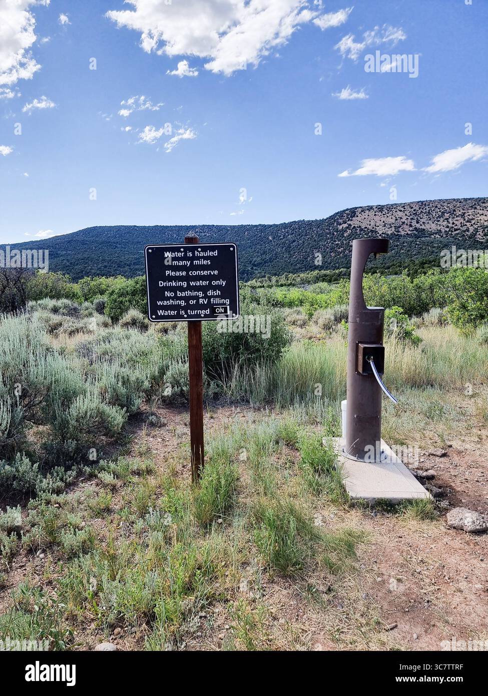 Water tap in a National Park with sign requesting to conserve water, use it only as drinking water since it is hauled many miles - Smartphone Captured Stock Image