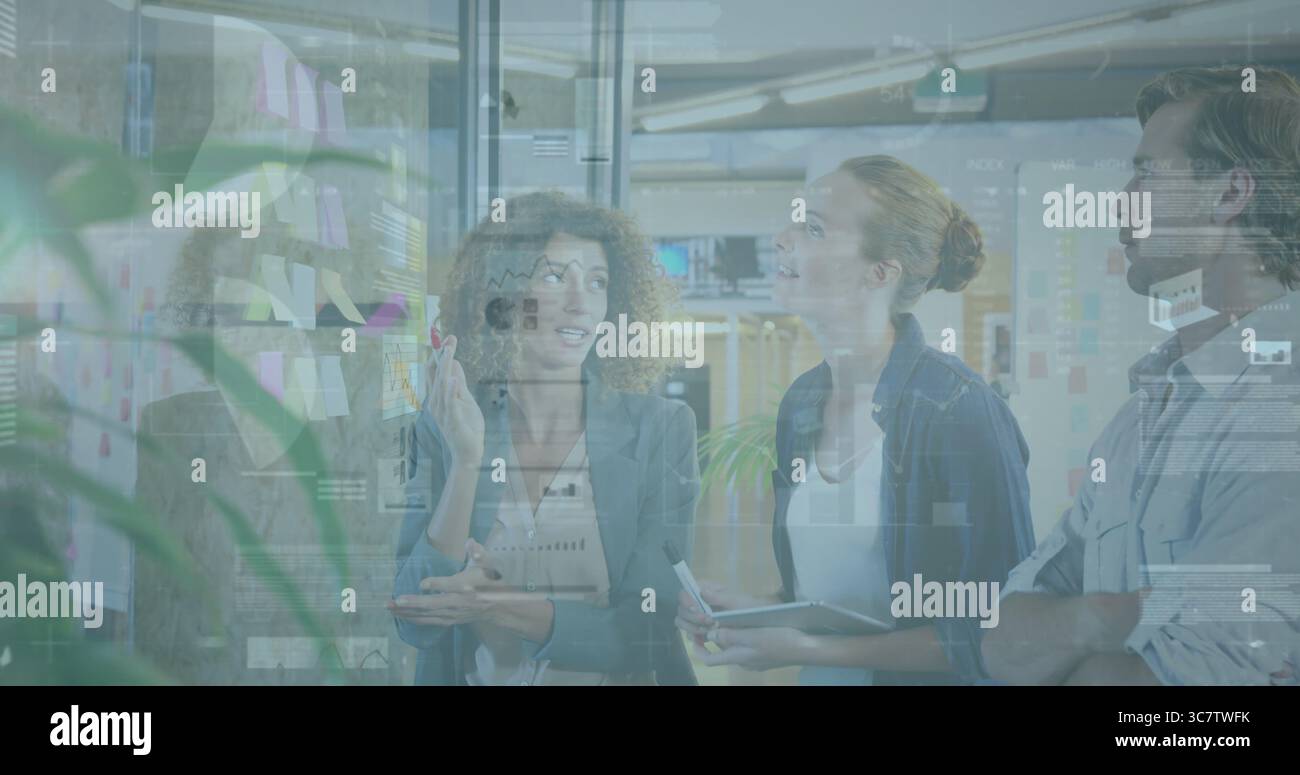 Brainstorming three professionals in office attire annotating glass in workspace with sticky notes Stock Photo