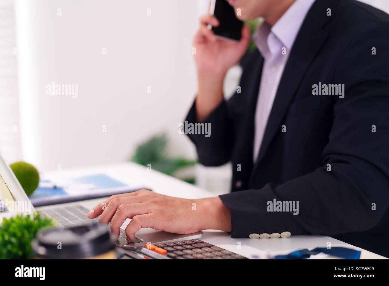 Pro At Using Computers Adult Asian professional using computer and smartphone managing tasks ...