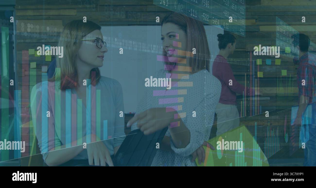 Discussing data on tablet and documents, two colleagues collaborating in office with sticky notes Stock Photo