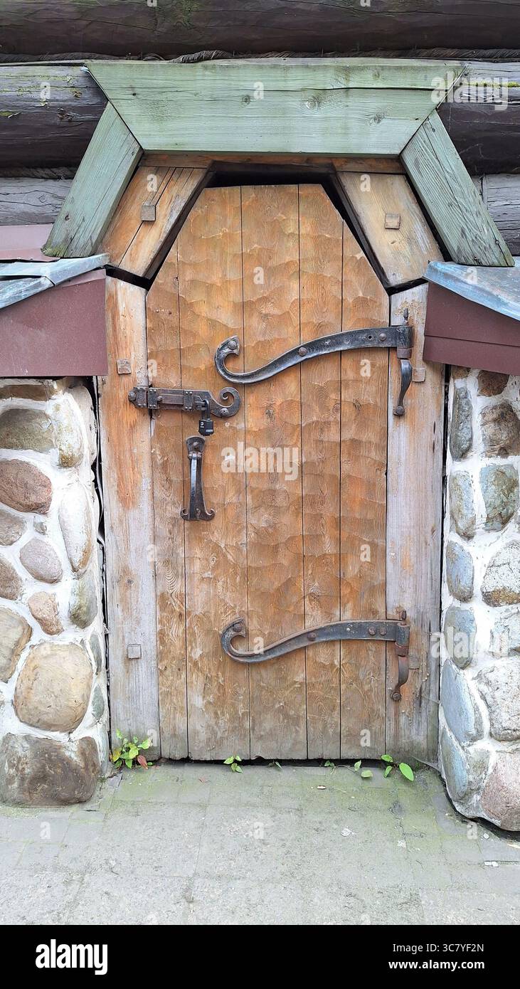 Rustic wooden door with iron hardware and stone surround in ...