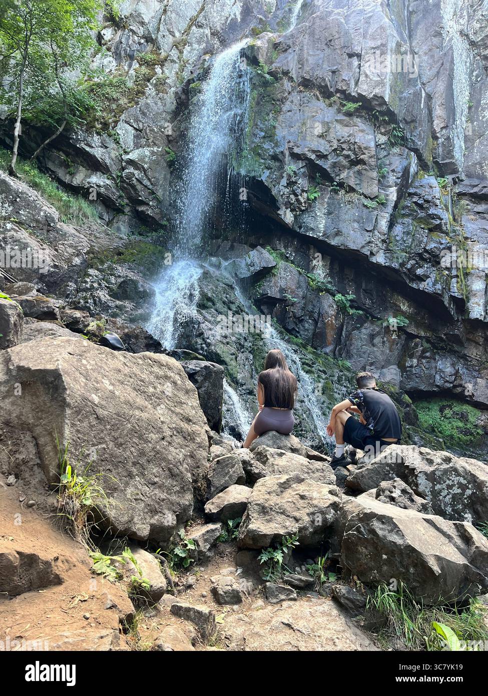 Couple of hikers at the Boyana waterfall in Summer in Vitosha Mountain near Sofia Bulgaria, Southeastern Europe, Balkans - Smartphone Captured Stock Image