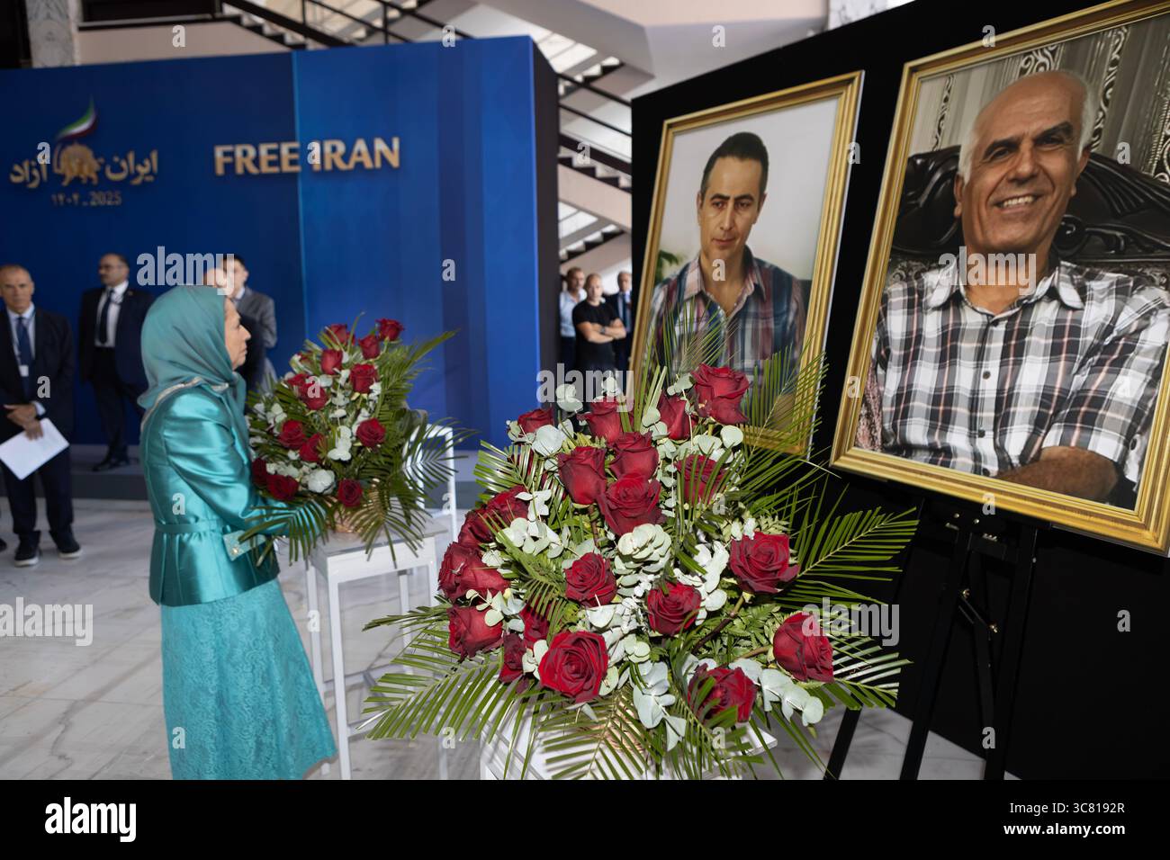 Maryam Rajavi is seen laying a wreath beneath portraits of Behrouz ...