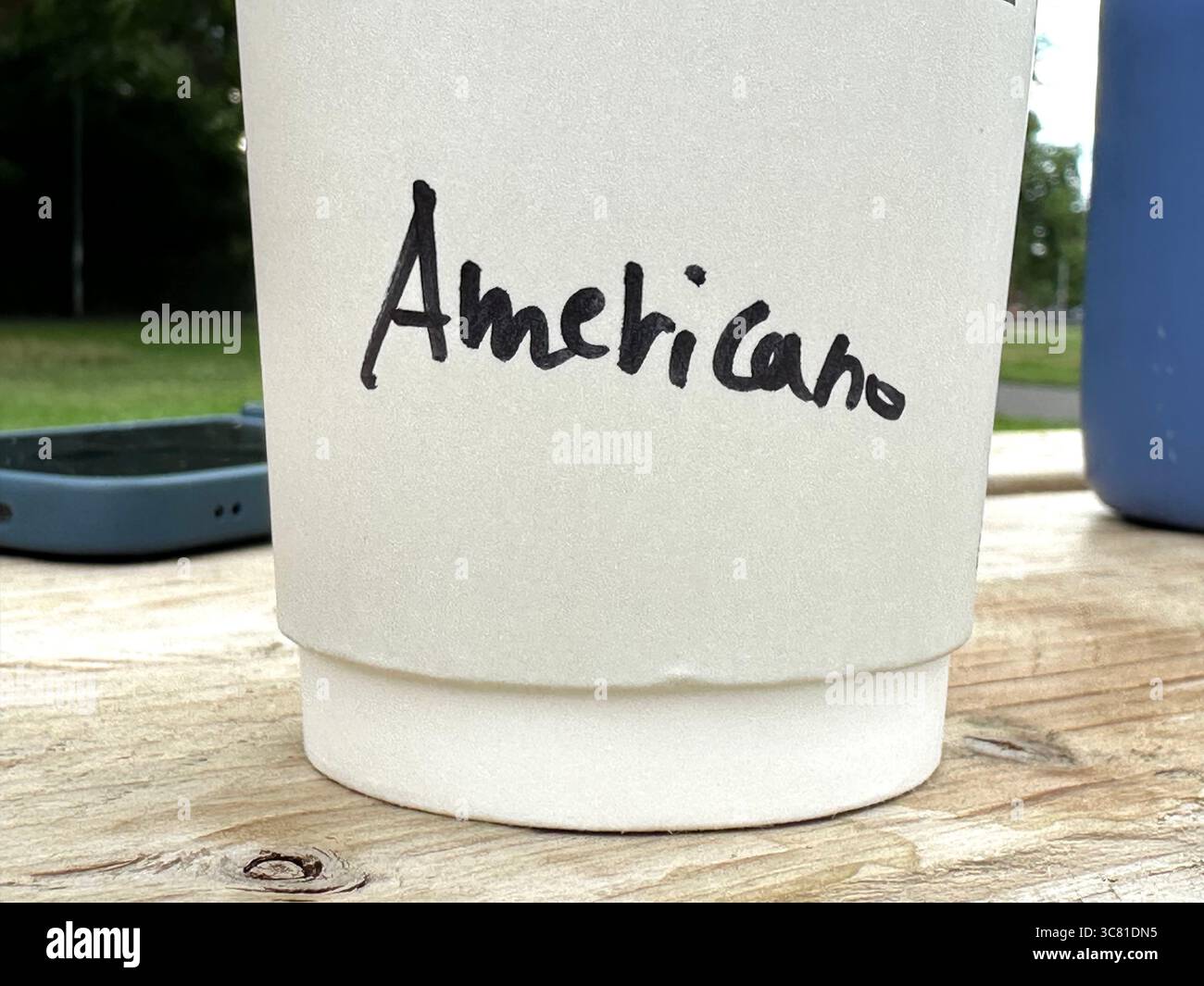 The bottom of a paper cup with the word Americano written on it - Smartphone Captured Stock Image
