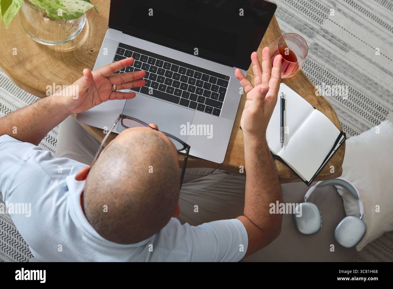 Man working from home, using laptop and smartphone while sitting on a comfortable sofa Stock Photo