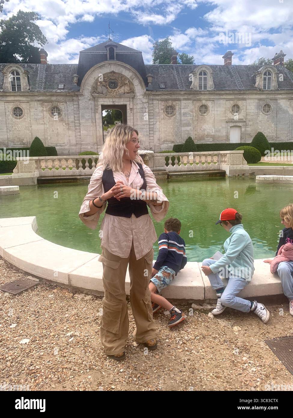Chateau Bizi France French monument historic place gardens museum old ancient fountain water lake piano harp playing play people performance - Smartphone Captured Stock Image