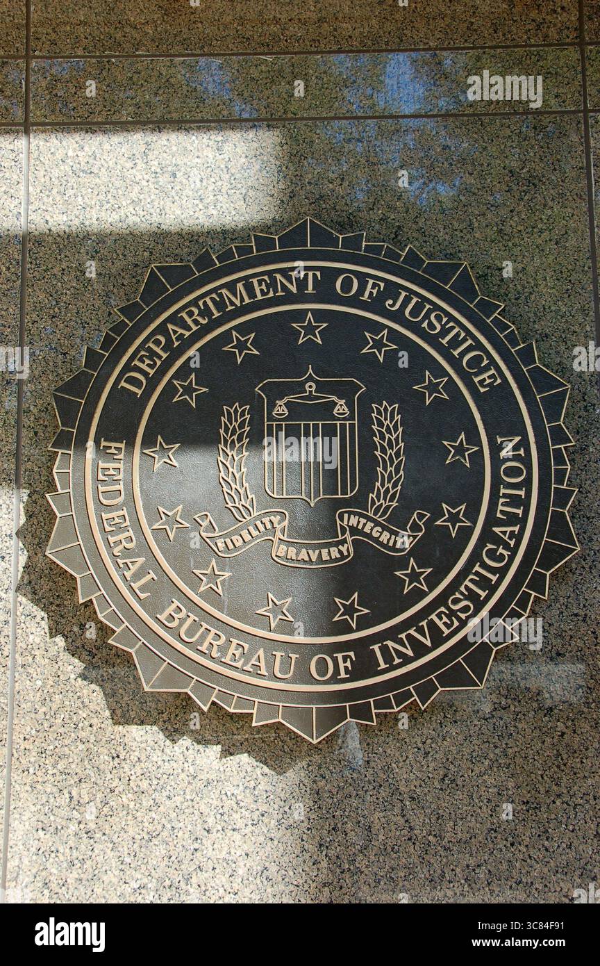 Bronze seal of the FBI, Department of Justice, featuring the motto “Fidelity, Bravery, Integrity,” mounted on a granite wall at headquarters Stock Photo